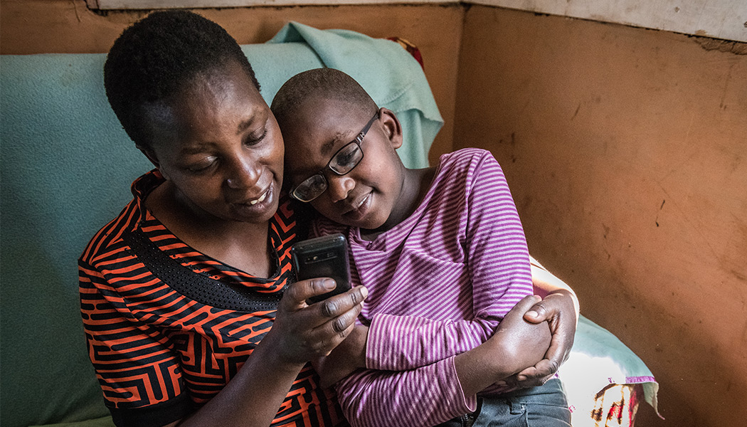 A-Mother-Helping-her-Child-on-Eneza-Educations-Mobile-Learning-Platform