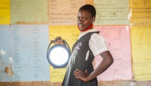 Student posing with a solar lamp