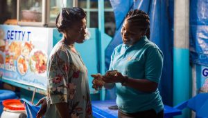 A representative from Affinity Africa shows a client how to use an app to transact business.