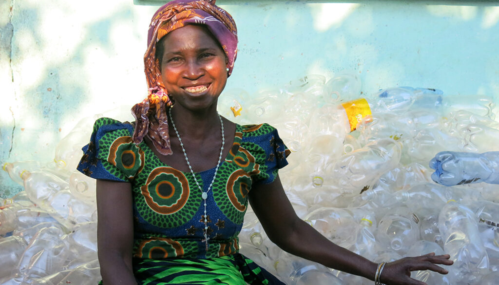 Benita Chikaluma sits with her bottles, demonstrating an important part of the definition of microcredit