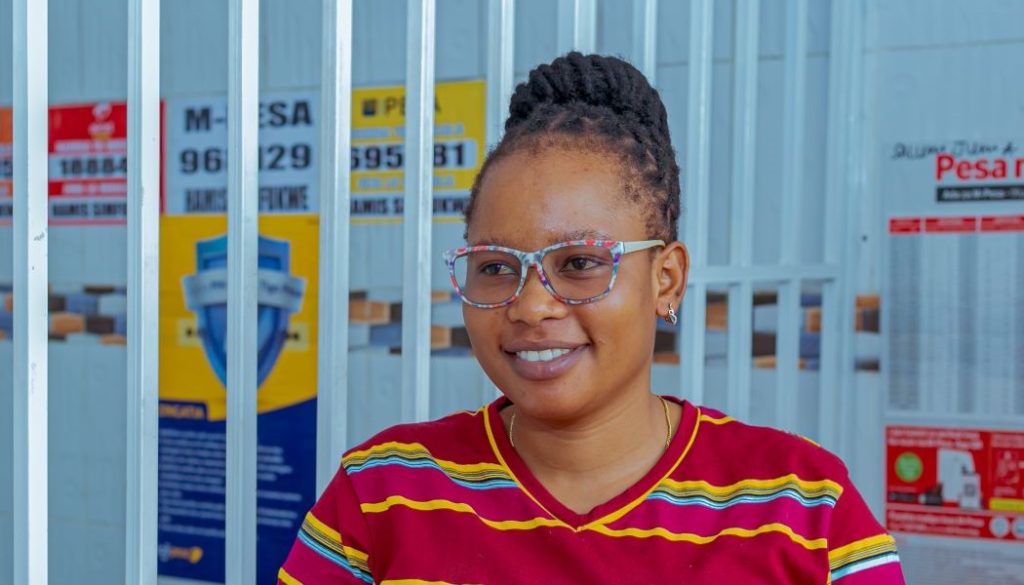 Happy Mtango at her kiosk where she works as an agent for FINCA.