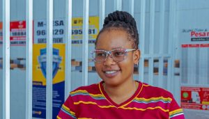 Happy Mtango at her kiosk where she works as an agent for FINCA.