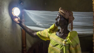 A BrightLife client adjusts the solar light on her solar home system.