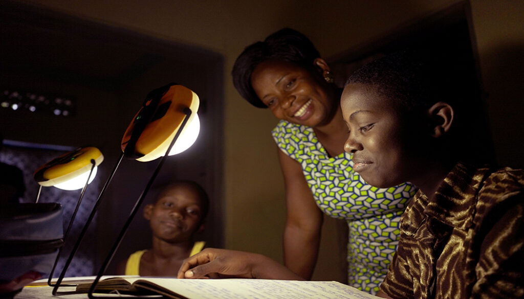 Student studying at night thanks to solar lamps