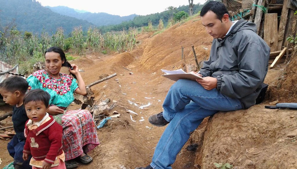 An enumerator interviews a FINCA client.