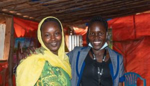 Hayat and FINCA Uganda's financial literacy officer, Vicky, share a moment at Hayat's restaurant.